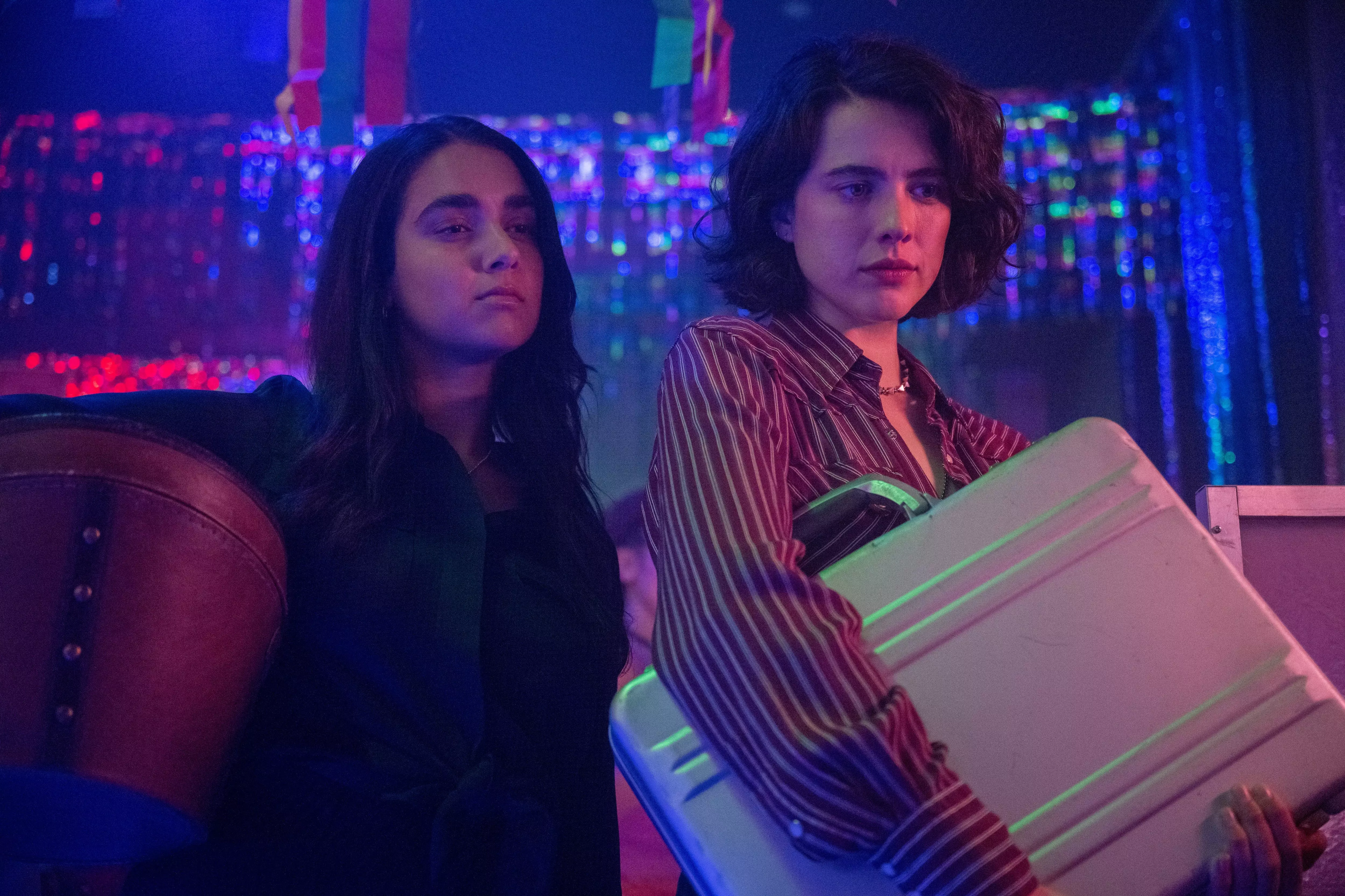 Geraldine Viswanathan (left) and Margaret Qualley play friends on a road trip who wind up with a wanted briefcase in the crime comedy "Drive-Away Dolls."