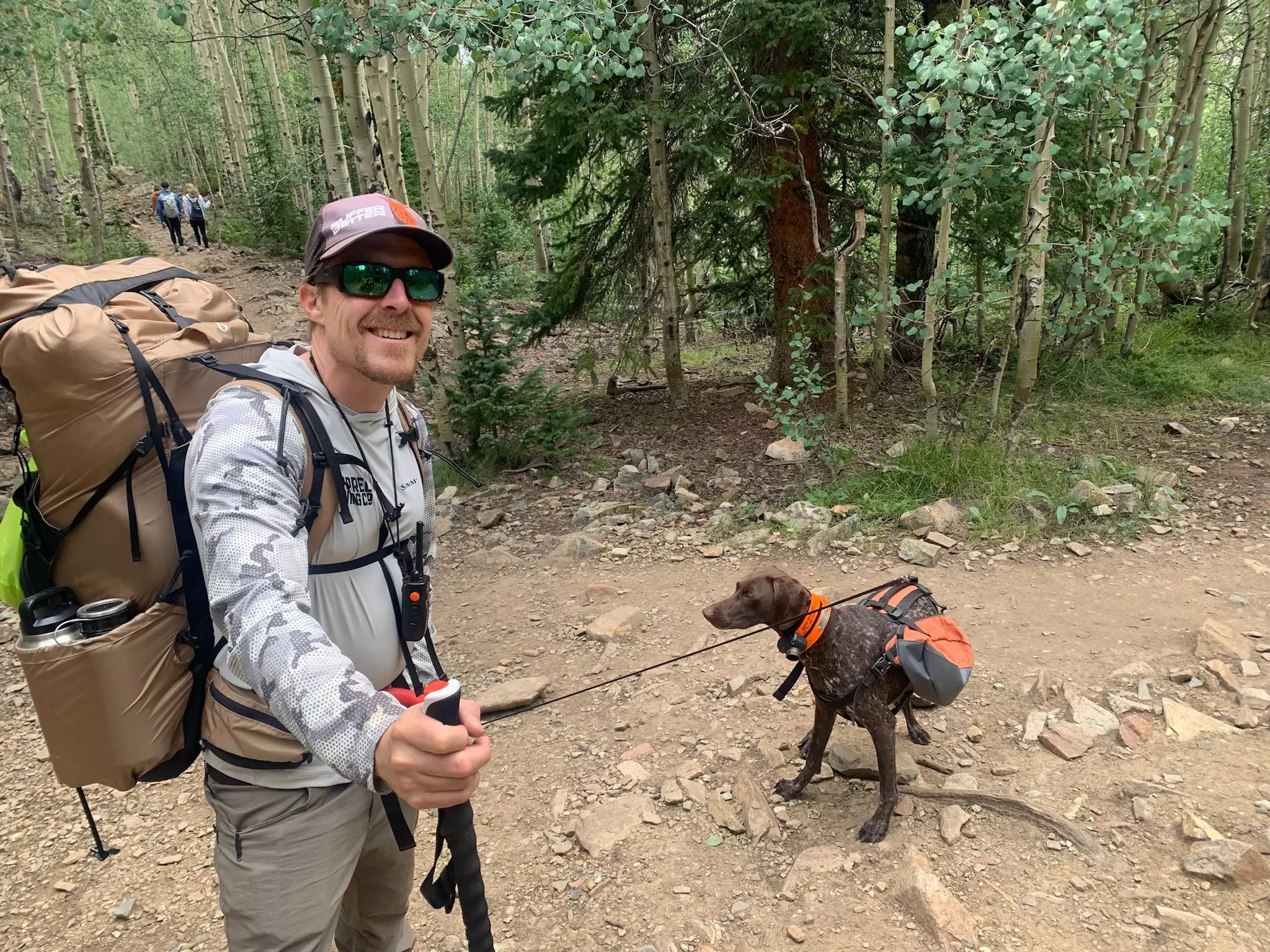 Man wearing Granite Gear Crown3 60 with a dog in the forest