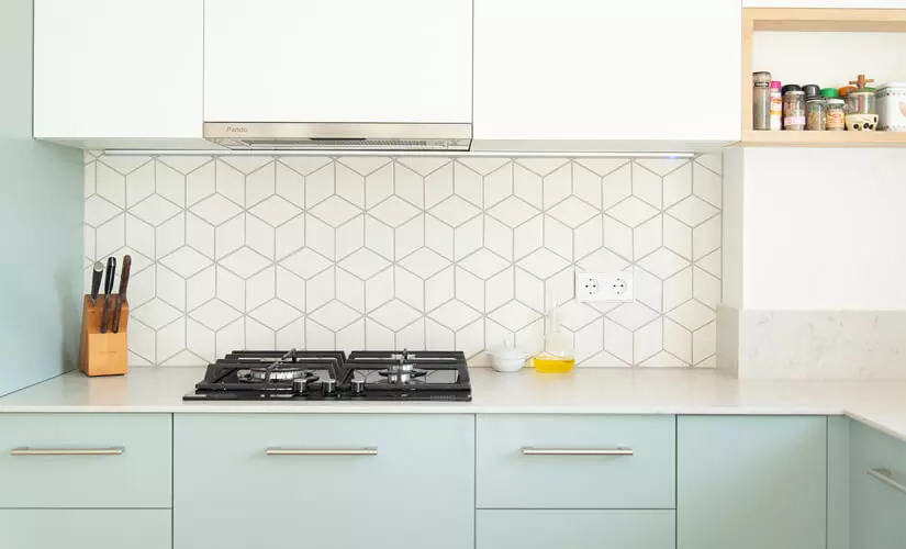 Mid-Century Modern kitchen with geometric tile backsplash and powder blue cabinets.