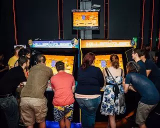 Group of people surround the Killer Queen, a 10-player real-time strategy game