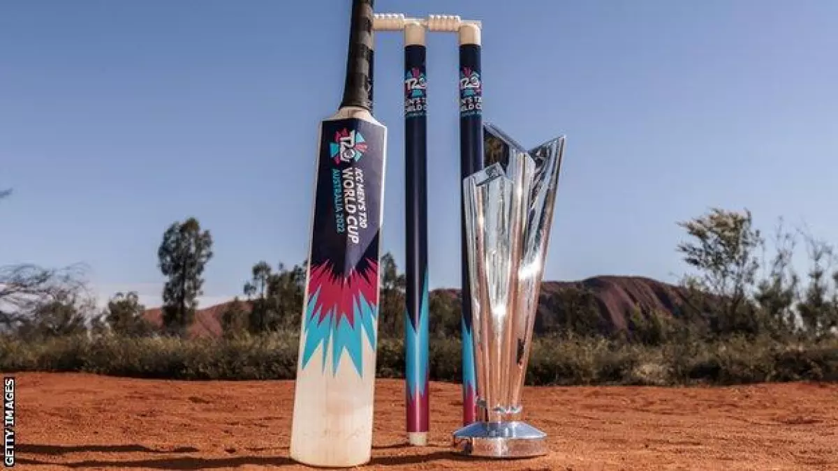 The T20 World Cup trophy next to some stumps and a cricket bat in the Australian outback