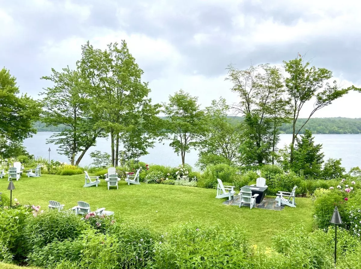 Garden with white chairs on lake- Three Pines Tour in Search of Louise Penny