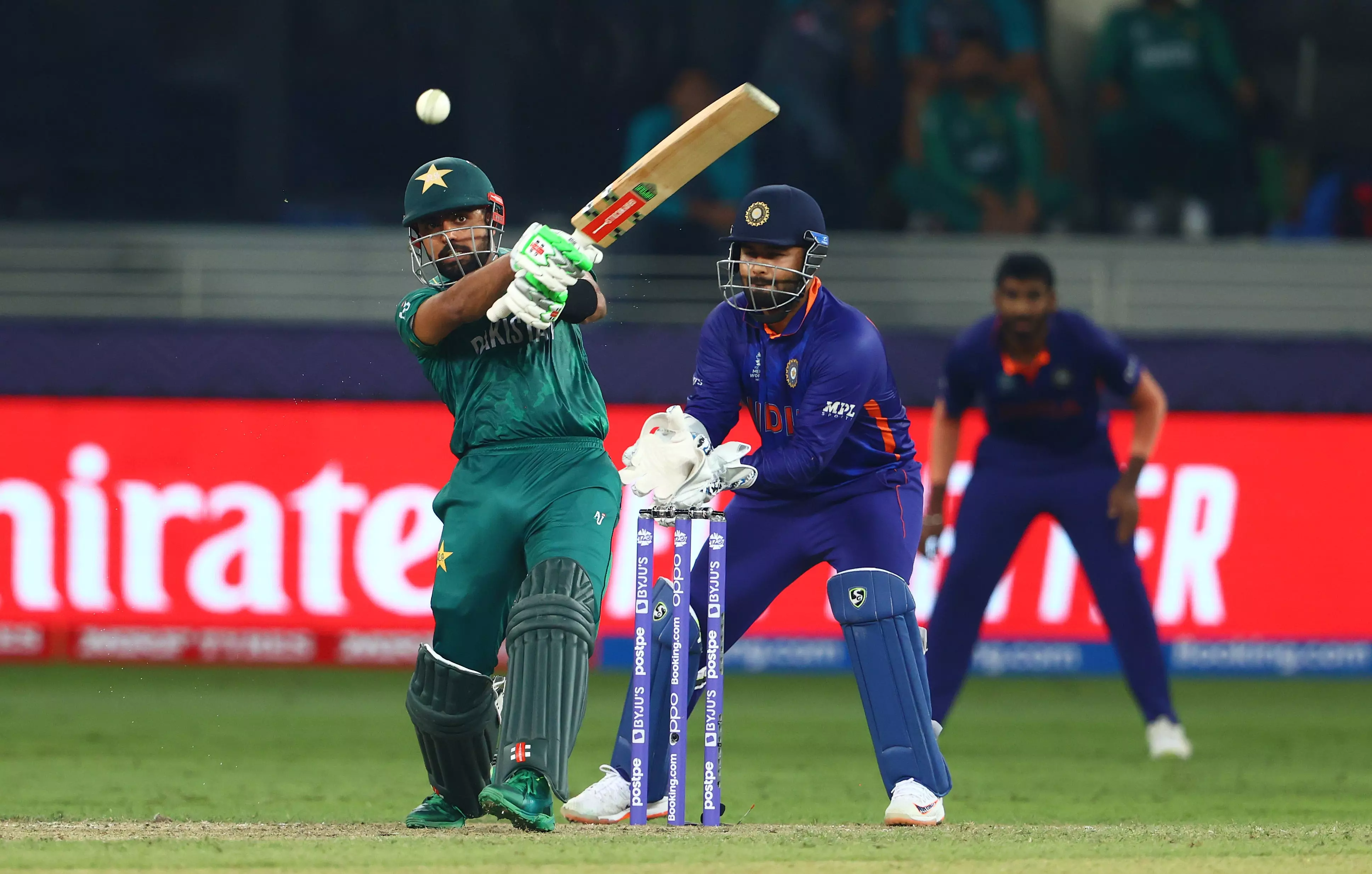 Babar Azam of Pakistan plays a shot as Rishabh Pant of India looks on during the ICC Men