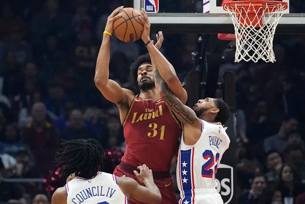 Cleveland Cavaliers center Jarrett Allen (31) grabs a pass in front of Philadelphia 76ers guards Ricky Council IV, left, and Cameron Payne (22) in the first half Monday in Cleveland.